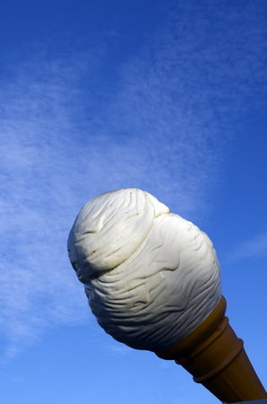 Giant vanilla ice cream cone isolated against blue sky with copy space.の写真素材