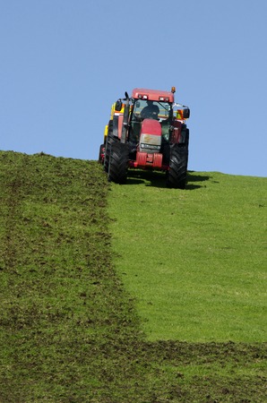 Red tractor plowing the ground in the autumn.