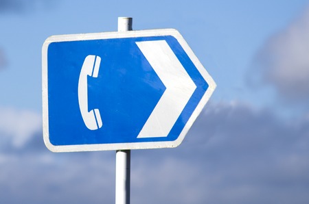 Old telephone sign outdoor against cloudy sky in the nature.の写真素材