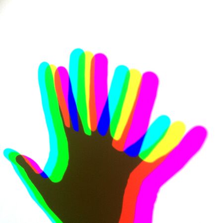 A human hand shades on a wall with RGB colours. Abstract background texture conceptの写真素材