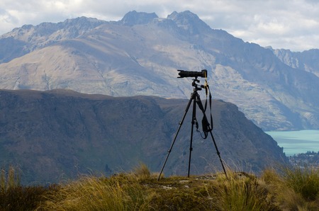Professional camera with telephoto lens on a tripod during landscape photography outdoor.の写真素材