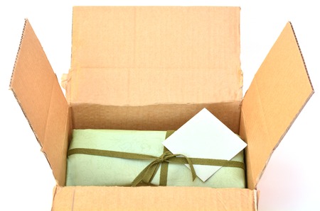 Olive green gift box with dark green ribbon and bow with gift card inside a cardboard delivery box.Concept photo of birthday, holidays, life events, wedding and special occasionの写真素材