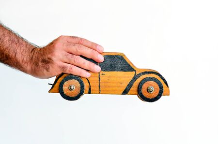 Hand holds toy car isolated on white background with copy space.Concept photo of car business, car Insurance, auto dealership,car rental ,safe driving ,buying, renting, fuel, service and repair costsの写真素材