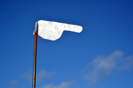 Hand shaped steel weathervane isolated against a bright blue sky. Concept photo of weather condition, change, point, pointing,travel, sign, journey,  indicate, informationの写真素材