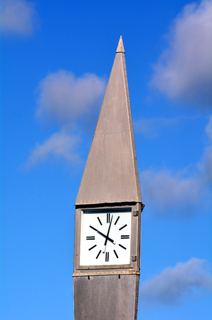 Street clock in the morning against a blue sky with white clouds. concept photo of time. Vertical