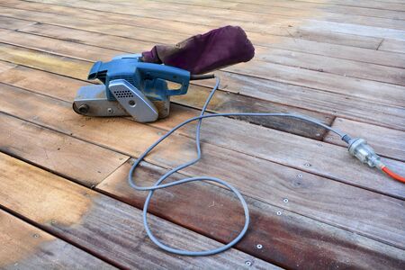 Working tool,  sander,  on old wooden deck. Concept photo, background texture image with copy- space