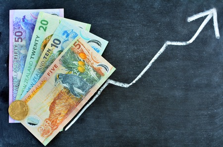 New Zealand Dollar Banknotes on upward trend arrow. Concept photo of money, banking ,currency and...
