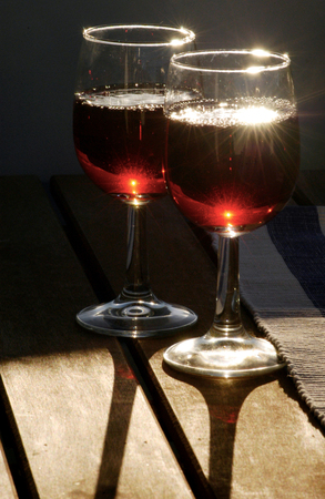 Two glasses of red wine during romantic sunset.の写真素材