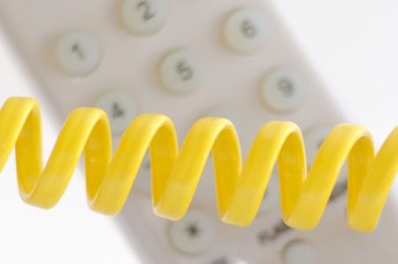 Telephone and cord on a white backgroundの写真素材