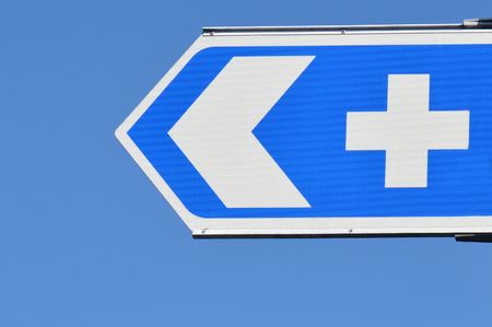 Hospital road sign against blue sky.concept photo of health and medical care.の写真素材