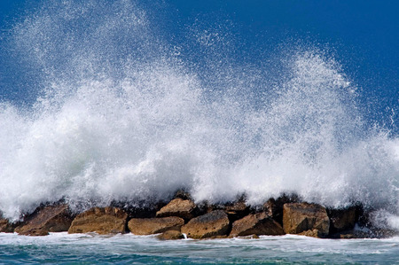 Big waves crashig on breakwater structure.