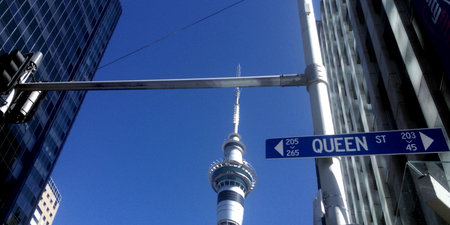 AUCKLAND, NZL - SEP 12 2015:Queen street sign against Auckland Sky tower.It's a major commercial thoroughfare in the Auckland CBD, New Zealand's main population centerのeditorial素材