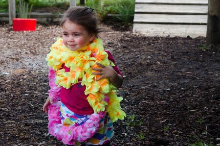 little  girl wearing a Hawaiian lei in a playground.の写真素材