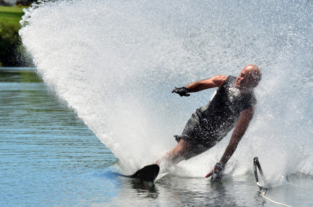 A water skier in his 60's preforming water skiing sport on a lake.の写真素材