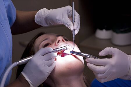 Female patient having her teeth examined by specialist dentist.の写真素材