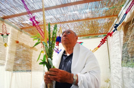 A Jewish man bless on the four species in the Sukkah in Sukkoth jewish holiday.の写真素材