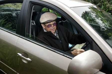 A very old man with a valid driving license drives his car.の写真素材