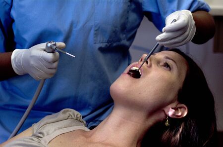 Female patient having her teeth examined by specialist dentist.