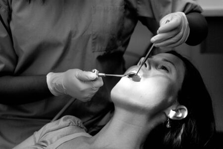 Female patient having her teeth examined by specialist dentist. (BW)の写真素材