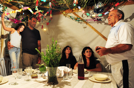 Israeli Jewish family celebrating the Jewish holiday of Sukkoth.の写真素材