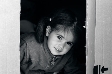 Portrait of a girl in a cardboard box during house moving. concept photoの写真素材