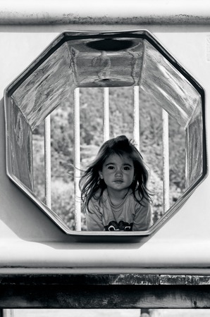 Attractive little girl on outdoor playground equipment (BW)の写真素材