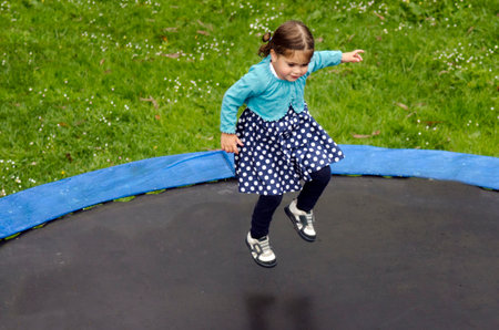 AUCKLAND OCT 08:Girl(Talya Ben-Ari age 3) jumps on trampoline on Oct 2010.Statistics show that about 80,000 children were treated in hospital emergency rooms for trampoline-related injuries every yearのeditorial素材