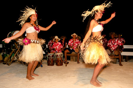 Portrait of Polynesian Pacific Island Tahitian female dancer in colorful costume dancing on tropical beach.のeditorial素材