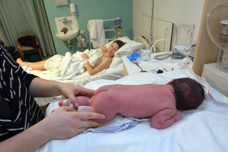 AUCKLAND - JUNE 07 2014:Newborn baby during childbirth examination.Approximately 370,000 babies born every day worldwide.The current births worldwide is estimated at about 134 million per year.のeditorial素材