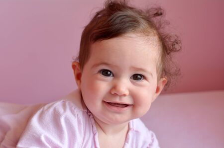 Happy baby (girl age 06 months) smiles. Concept photo childhood. copy spaceの写真素材
