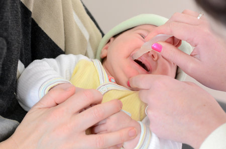 AUCKLAND - AUG 14 2014:Nurse giving a baby Rotavirus vaccine immunisation.It protects children from rotaviruses, which are the leading cause of severe diarrhea among infants and young childrenのeditorial素材