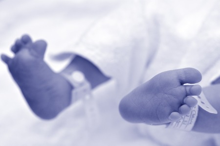Newborn baby feet with identification bracelet tag name. (BW)の写真素材