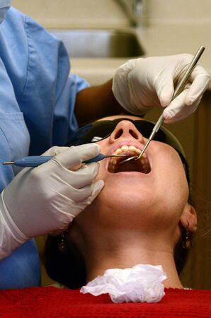 KAITAIA, NZ - NOV 05:Female patient having her teeth examined by specialist dentist on Nov 05 2013.About 75% of US adults experiences dental fear. Up to 10% are considered to experience dental phobia.の写真素材