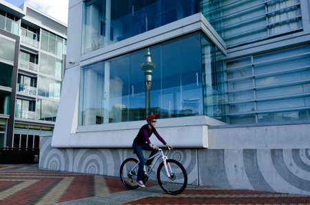AUCKLAND - MAY 26:Woman ride bike Auckland Viaduct Harbor Basin on May 26 2013.It's a former commercial harbor turned into a development of mostly upscale apartments, office space and restaurants.のeditorial素材