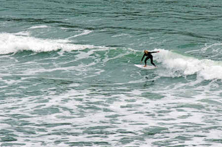 PIHA, NZ - JUNE 01:Wave surfer rids a wave in Piha beach on June 01 2013.According to the...