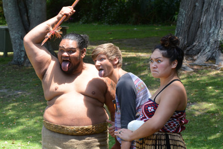 WAITANGI, NZ - FEB 06:Tourist having fun with Maori people on February 6 2014 in Waitangi NZ.It's a New Zealand public holiday to celebrate the signing of the Treaty of Waitangi in 1840.のeditorial素材