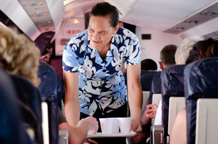 AITUTAKI - SEP 17:Air Rarotonga air hostess serves hot drinks during flight on Sep 17 2013.The...