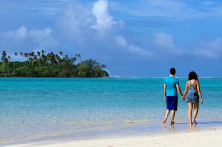 RAROTONGA - SEP 17:Couple on Honeymoon walks on Muri lagoon on Sep 17 2013.Cooks Islands are major travel destination for couples from NZ and Australia that married on the beach of a Pacific island.のeditorial素材