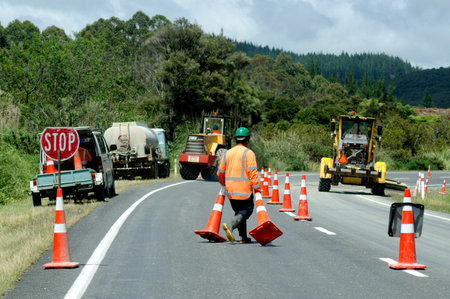CABLE BAY, NZ - DEC 12:Road worker slows traffic with stop sign on Dec 12 2013.There are more than...