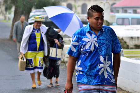 RAROTONGA - SEP 16 2013:Cook Islanders walks in tropical rain.The Cook Islands' main population centers are on the island of Rarotonga (14,153 in 2006)のeditorial素材