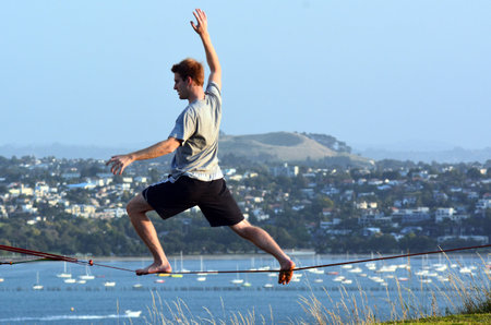 AUCKLAND, NZ - JAN 18:Young man walk on a rope on Jan 18 2014. Tight rope walking has been around at least two thousand years originated in ancient China.のeditorial素材