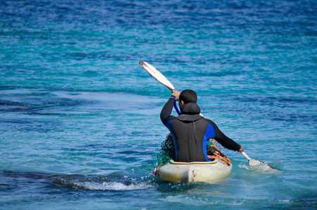 RANGIPUTA, NZ - DEC 20:Man kayaking in Rangiputa beach on Dec 20 2013.Kayaks can be useful in outdoor activities such as diving, fishing, wilderness exploration and search and rescue during floods.のeditorial素材