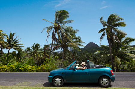 RAROTONGA - SEP 21:Woman travel by car in Rarotonga Island on Sep 21 2013.Cooks Islands are largely unspoiled by tourism with 100,000 visitors a year.They one of the world's most remote Islands.のeditorial素材
