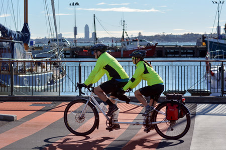 AUCKLAND,NZ - JUNE 01 2014:Couple rids tandem bicycle.Compared to a conventional bicycle, a tandem has double the pedalling power and with only slightly more frictional loss in the drivetrain.のeditorial素材