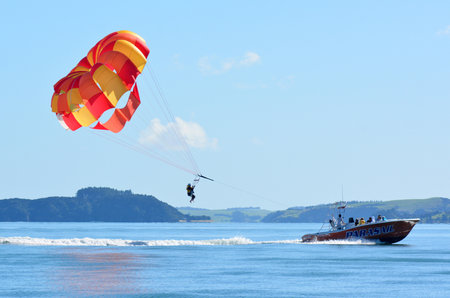 BAY OF ISLANDS, NZ - MAY 11 2014:Person Parasailing in the Bay of Islands.It is one of the most popular fishing, sailing and tourist destinations in New Zealand.のeditorial素材