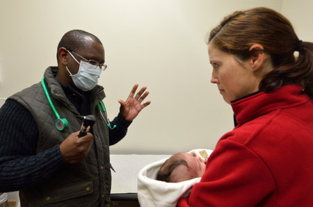 AUCKLAND - JULY 23 2014:Doctor talks to a mother of a newborn baby.The cost of delivering a new baby can get up to $8,000 not including numerous well-visit checkups and immunizations after childbirth.のeditorial素材
