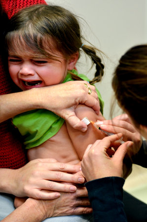 TAIPA, NZL - MAY 16 2014:A child (Talya Ben Ari age 4) receives an immunization of DPT and MMR vaccine New vaccines could avert nearly 4 million deaths of children under the age 5 by 2015.のeditorial素材