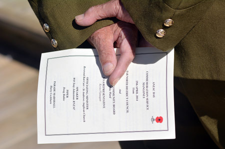 New Zealand Army veteran soldier hands holds  ANZAC order of service during a National War Memorial Anzac Day in New Zealand.のeditorial素材