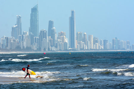 GOLD COAST - NOV 02 2014: Surfer in Burleigh head beach with Surfers Paradise skyline in the background .It is a very popular surfing beach in Gold Coast Queensland, Australia.のeditorial素材
