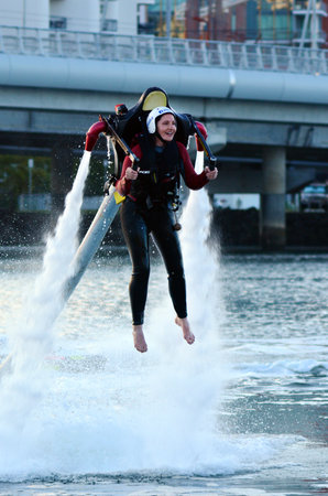 GOLD COAST - OCT 10 2014: Woman ride a Jet pack.The first jet pack was developed in 1919 by the Russian inventor Aleksandr Fyodorovich Andreyev.のeditorial素材